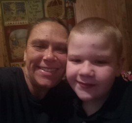 A white kin caregiver and young kin child smile for a close-up picture