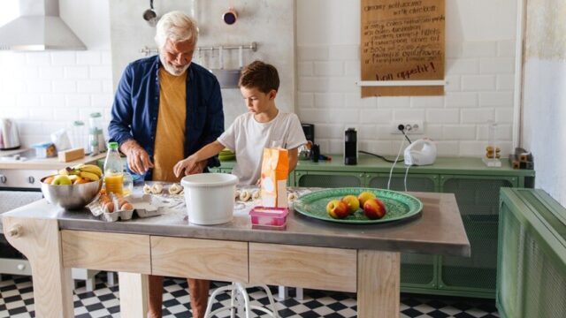 Grandfather and grandson cooking in a kitchen.