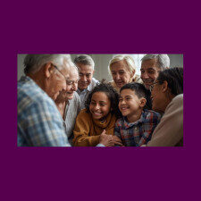 A group of older adults smiling around a young girl and boy