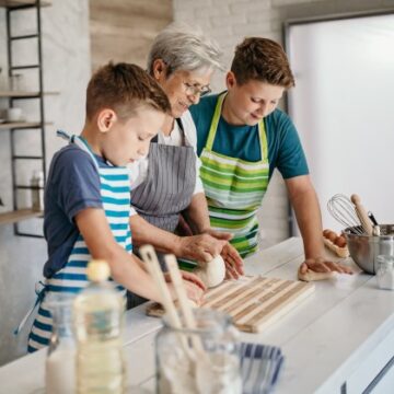 A grandmother and her two grandsons cook together