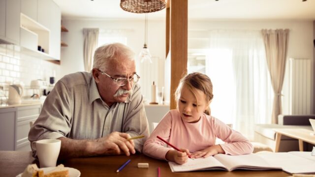 A white grandfather and granddaughter color together