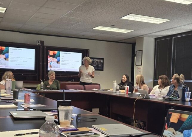 A group of professional women in Idaho sit at a conference table for a presentation